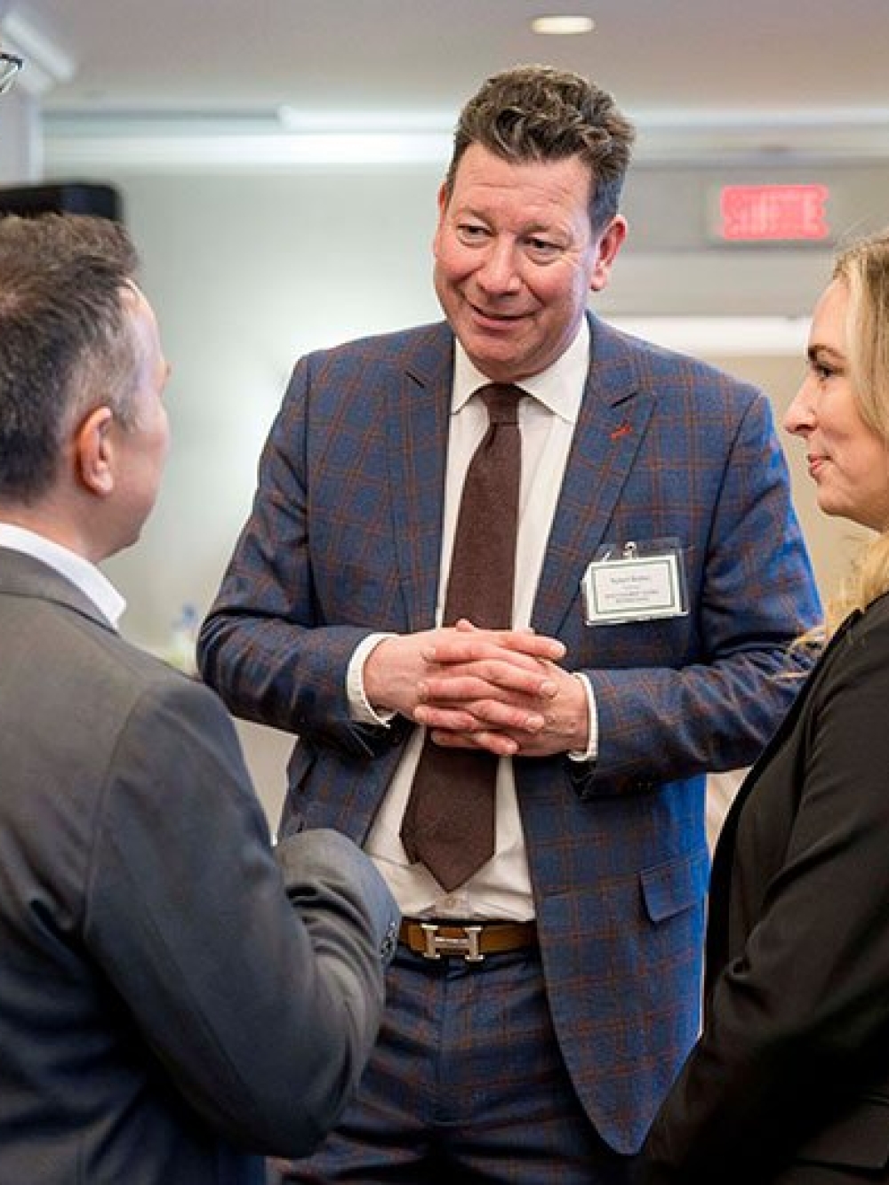 Groupe de personnes en discussion dans une salle de conférence, devant une bannière d’Investissement Québec. 